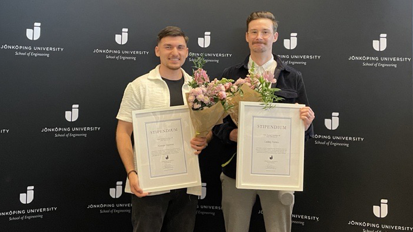 Två killar håller upp deras inramade stipendier och varsin bukett med blommor. De står framför en bakgrund med Jönköpings Universitets logga.