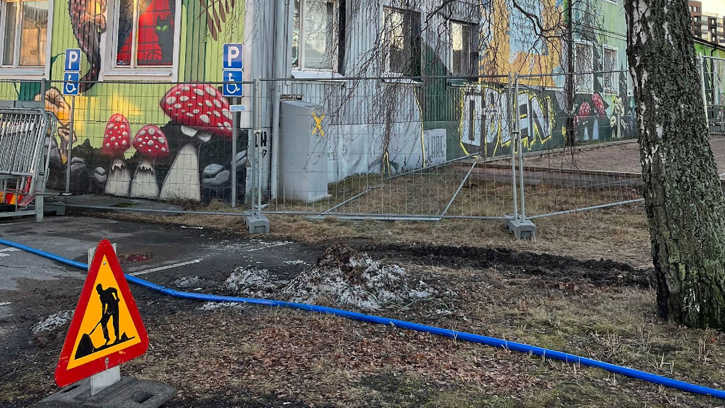 Byggstängsel står runt huset Kvarter Ödlan. Utanför stängslet ligger en slang och det står även en triangelformad skylt som visar att arbete pågår.