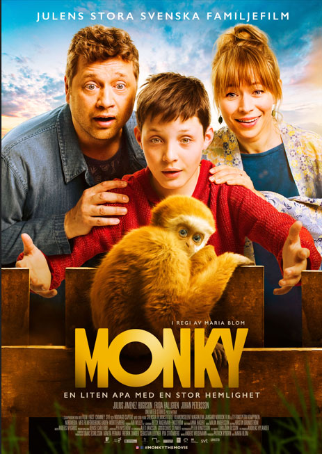 Pappa, mamma och och son på elva år befinner sig i mitten av bilden och täcker större delen av den. De är riktade mot kameran och ser förvånade, glada, förväntansfulla ut. Framför dem på ett staket sitter en apa och ser skygg ut. Nedanför i bilden står texten MONKY i guld.