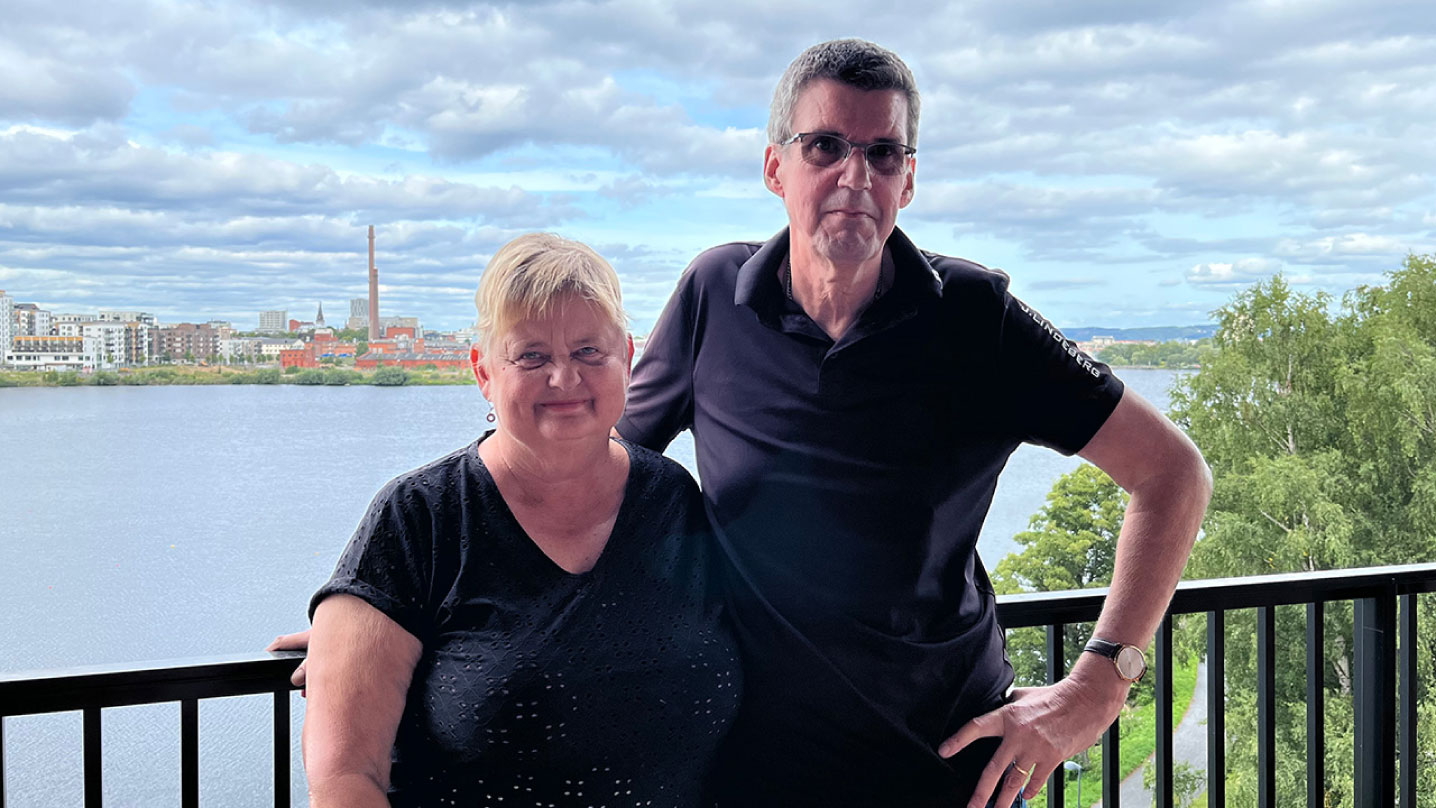 Birgitta och Håkan står på sin balkong som ligger högt över marken. Man ser Munksjön bakom dem.