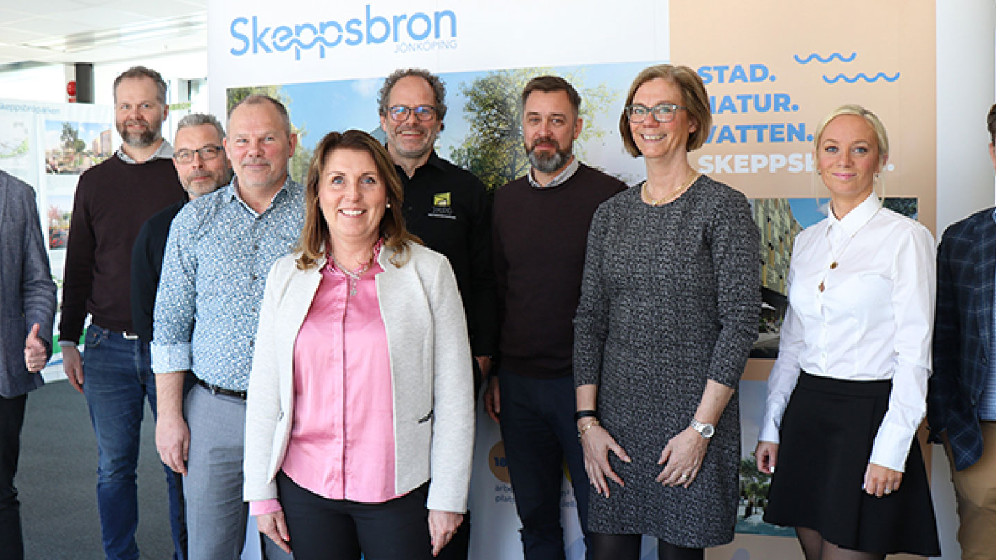Gruppbild på flertalet människor framför en vepa med Skeppsbron.