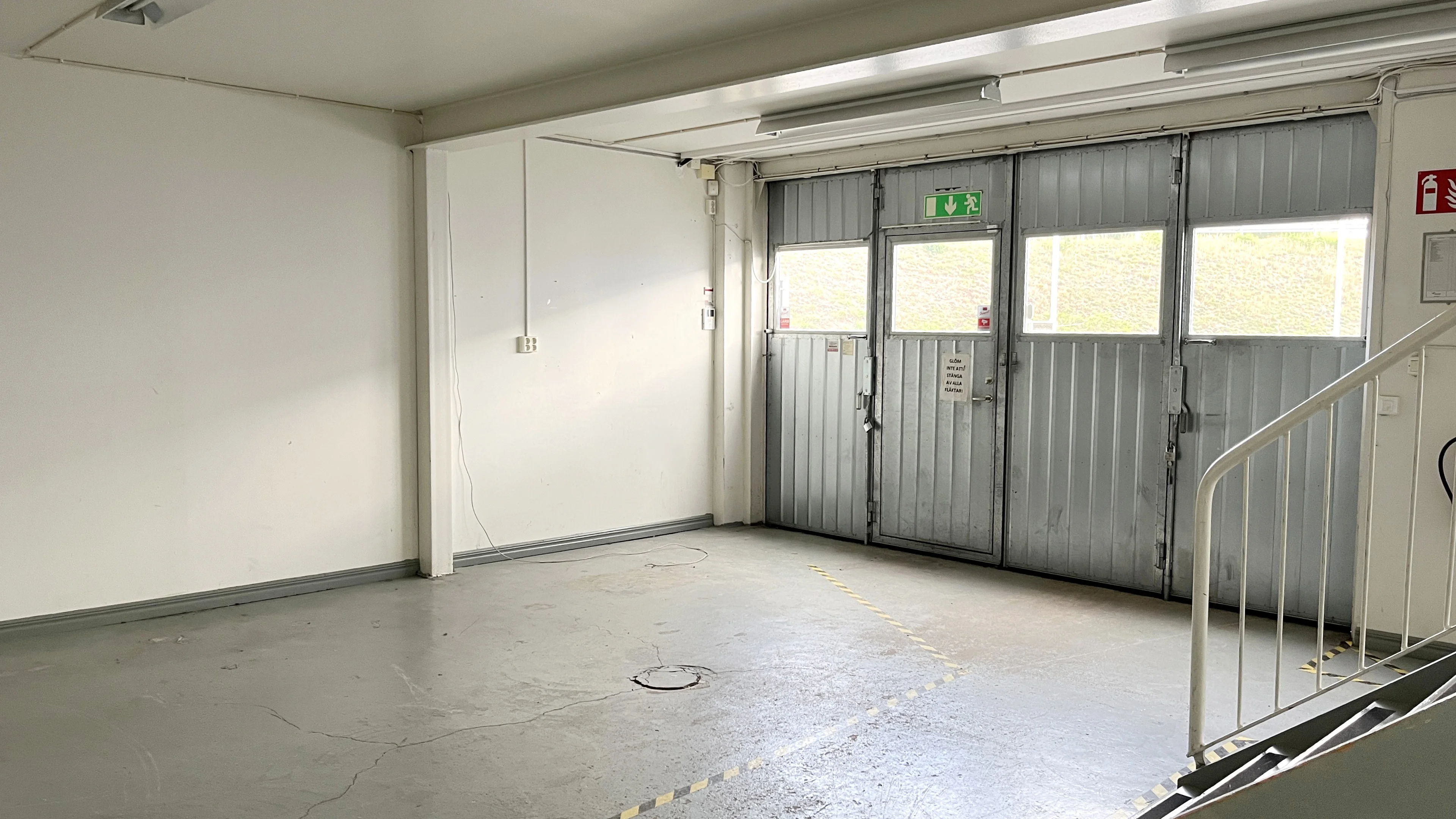 Lager med stor garageport på baksidan av lokalen.