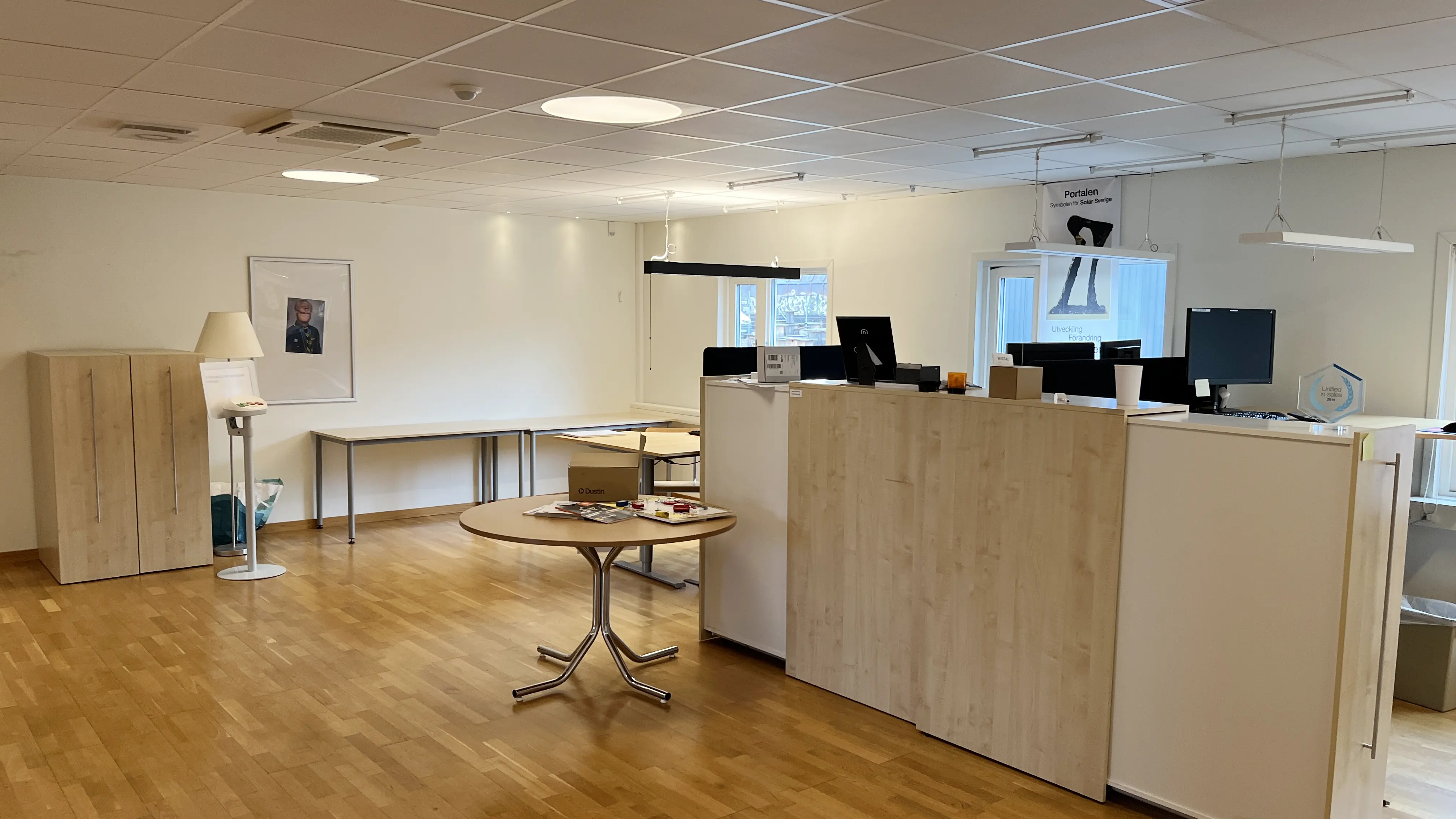 Öppen kontorsyta med arbetsplatser och förvaring.
