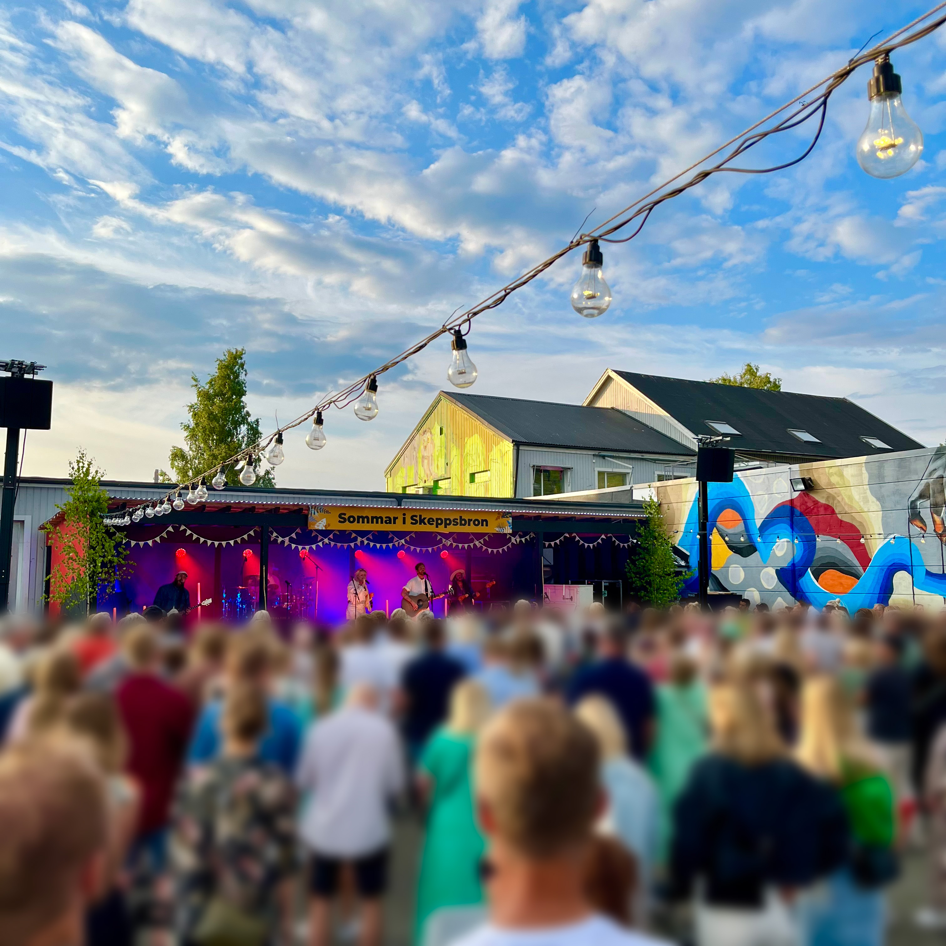 Bild från Ödlans innergård. Smith & Thell står på scen och framför scen står ett hav av sommarklädda människor och lyssnar. 