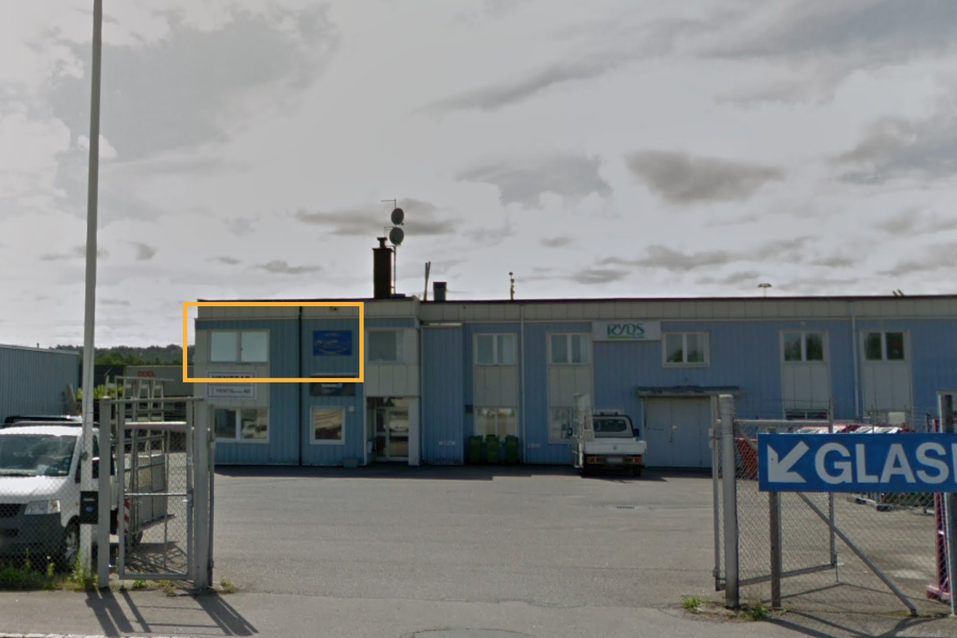 En ljusblå industribyggnad med vita fönster och detaljer. I det övre vänstra hörnet är det aktuella kontoret markerat med gult.