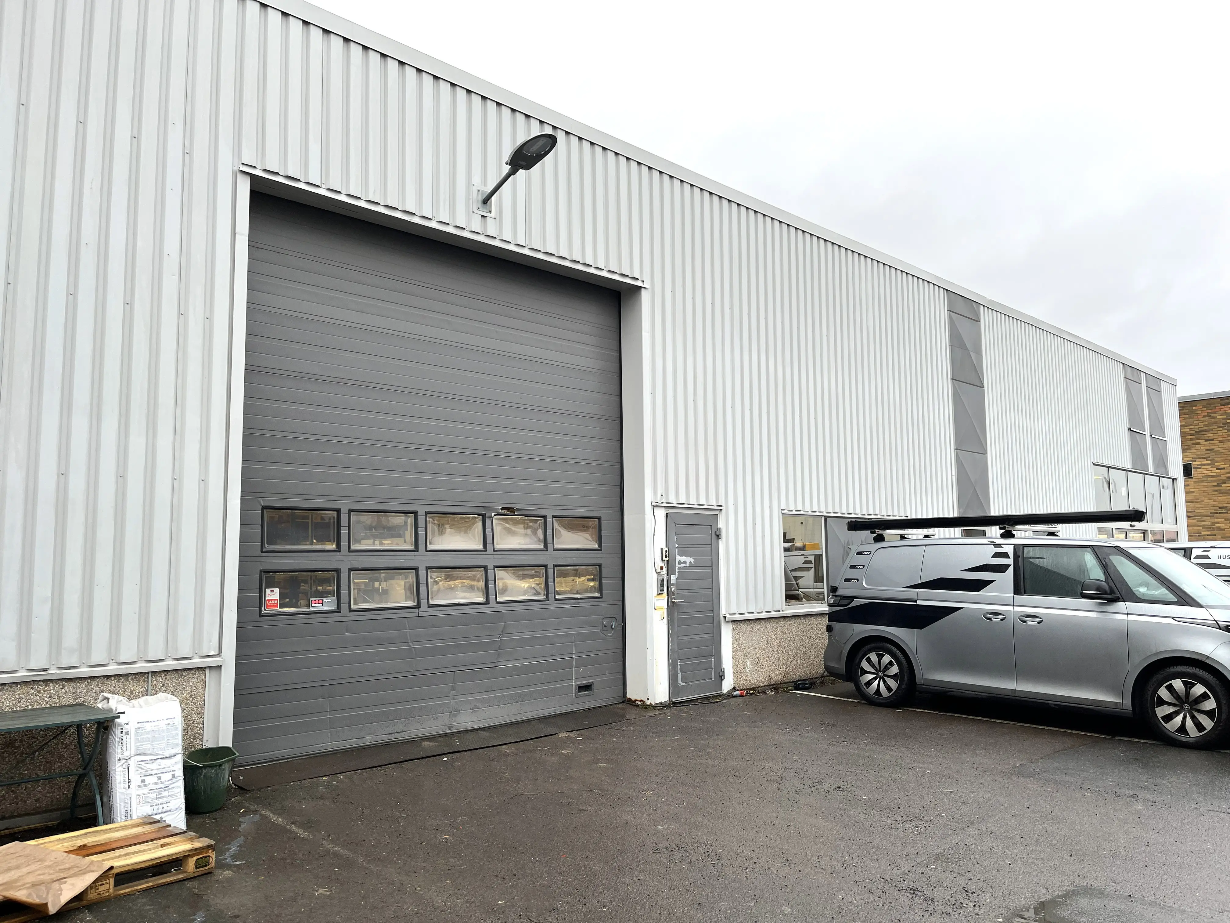 Stor grå port på en vit husfasad.