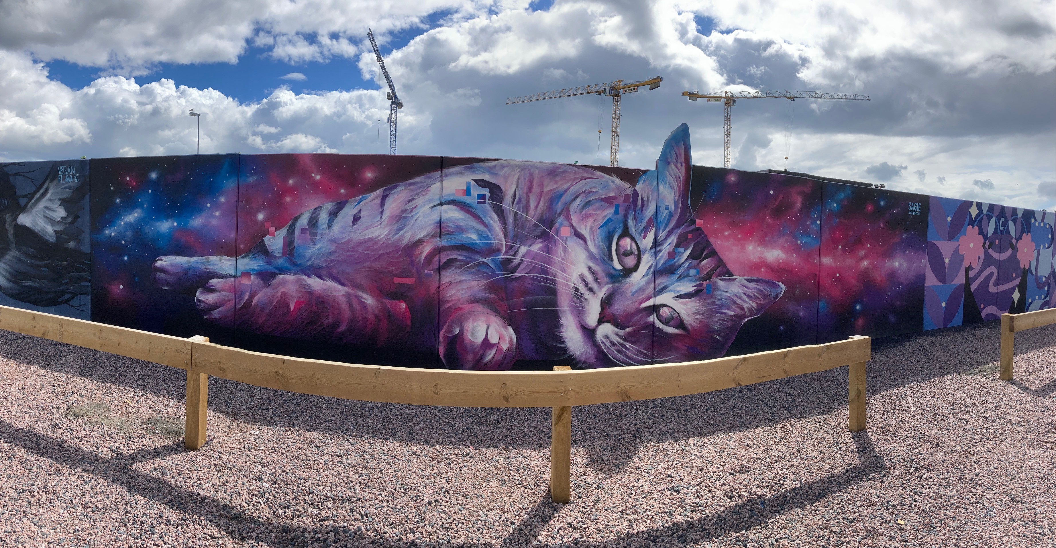 Christofer ”Sagie” Siwertz-Svedjeby muralmålning på Cementgatan föreställande en katt som ligger ner. I bakgrunden är det en färgexplosion i lila och blåa toner.