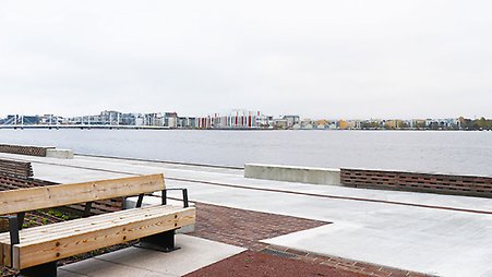 Foto över Munksjökajen. Till vänster en träsoffa på kajen och Munksjön syns bortanför kajen.