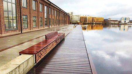 Kajen med röda tegelhus till vänster och sjön till höger.