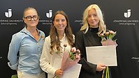 Bild på tre kvinnor. Två av dem håller blommor och diplom i handen.