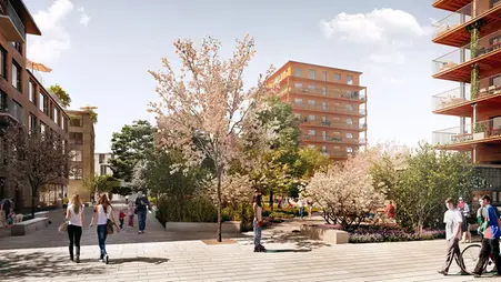 Grönskade park med planteringar och träd. Framför parken syns stenläggning och människor som rör sig. 