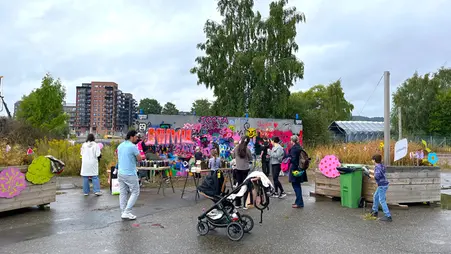 Vuxna och barn står framför en vägg och sprayar graffiti.