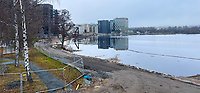 Utblick över byggområdet. Munksjön åt höger, bredvid syns stenar och en jordig väg. I bakgunden syns höghusen i Skeppsbron.