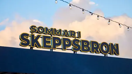 Bild på LED-skylt där det står Sommar i skeppsbron. Bakom skylten syns en blå himmel med moln.